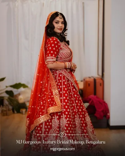 North Indian bride in a red lehenga with traditional jewellery and classic wedding makeup by MJ Gorgeous