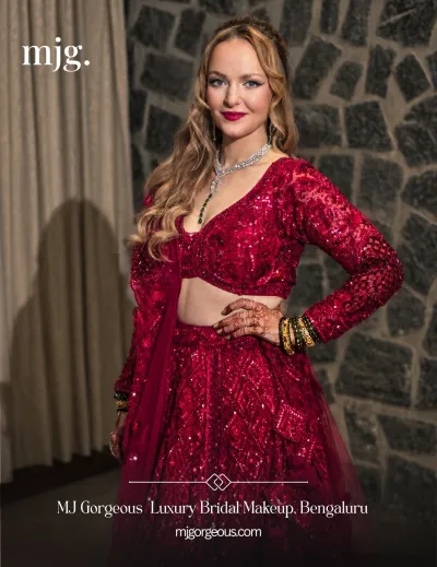Bride in a red reception lehenga with glamorous makeup and loose waves by MJ Gorgeous
