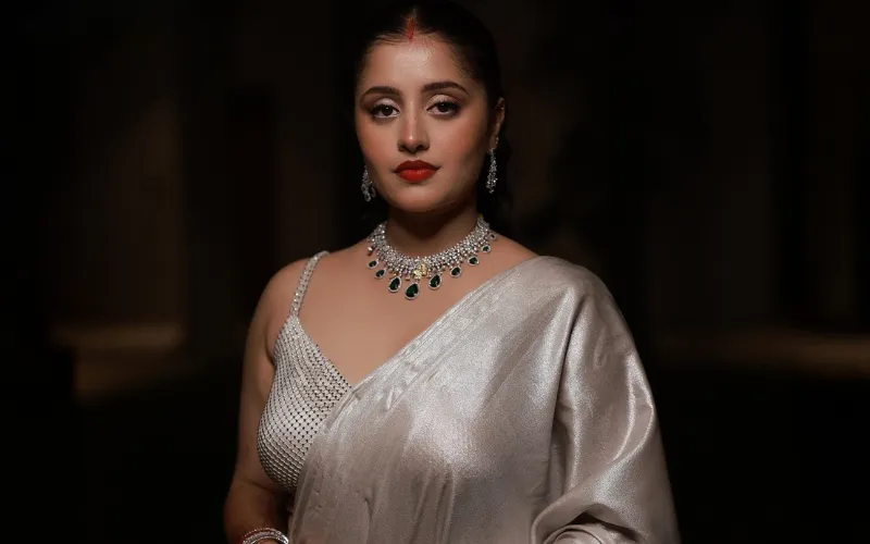 Bride in a pearl drape with emerald jewellery and a rich red lip for her wedding reception