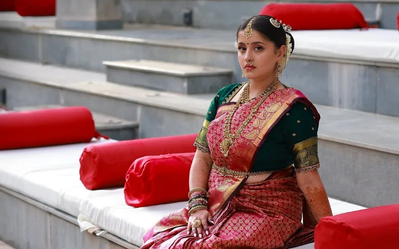 Tamil bride in a pink and gold silk sari with traditional jewellery and a flower-adorned bun